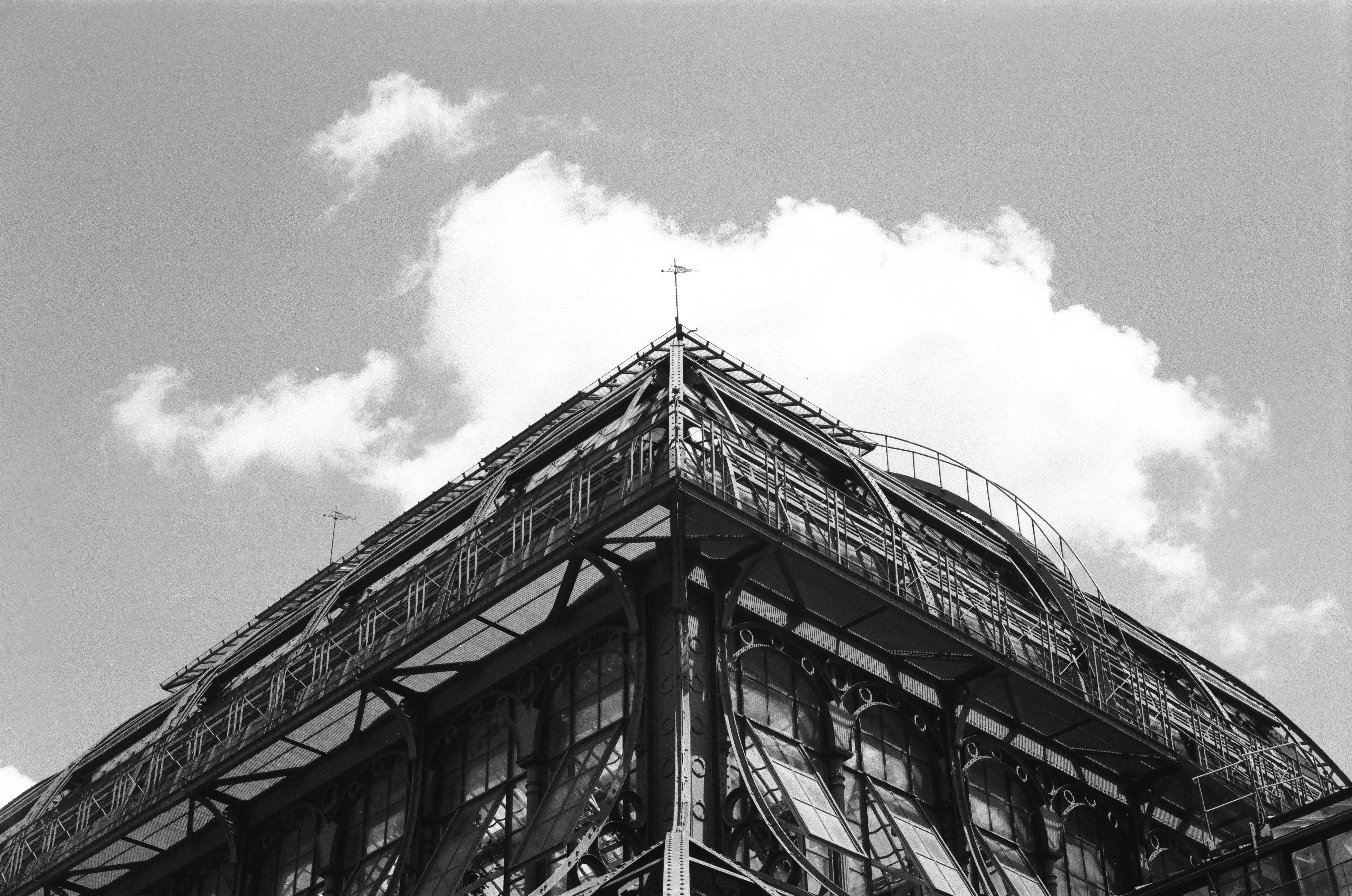 Glass-house roofline against dramatic clouds