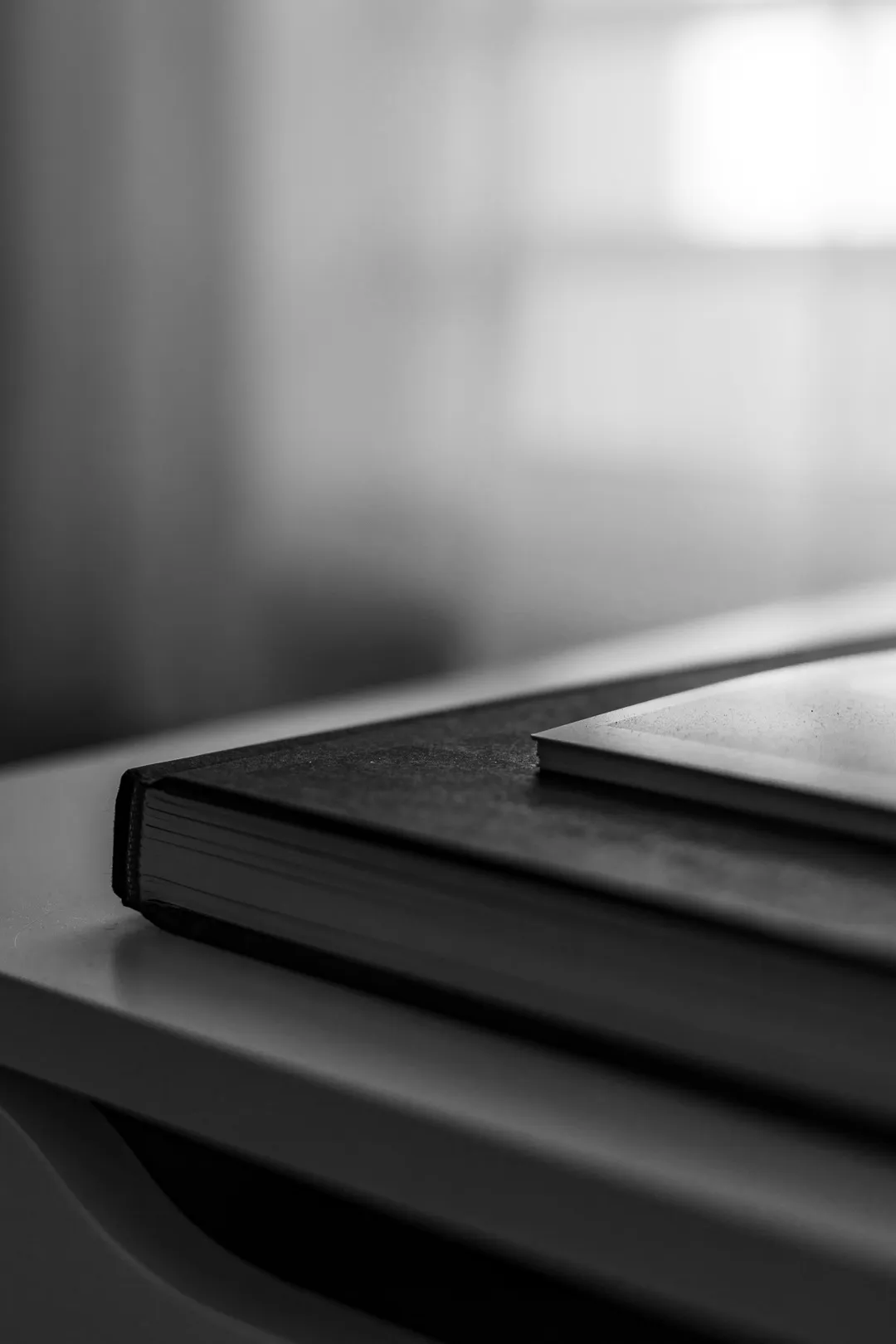 A black notebook on a windowsill in soft light