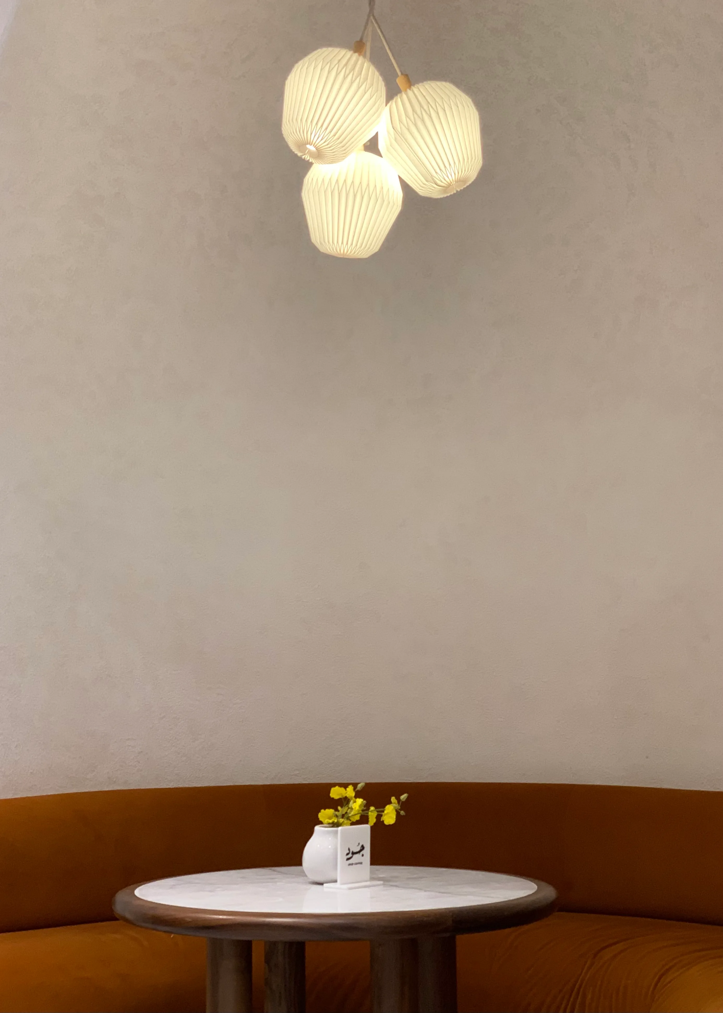 Cluster of pendant lamps above a marble café table